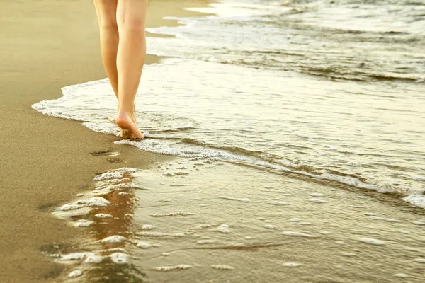 Mädchen hinterlässt Fußabdrücke im Sand — Stockfoto