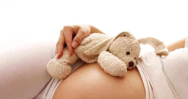 Живот беременная женщина с игрушкой — стоковое фото