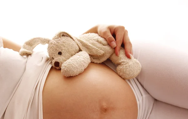 Bauch schwangere Frau mit Spielzeug — Stockfoto