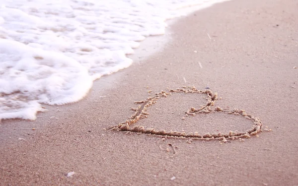 Heart in the sand on the seashore Stock Picture