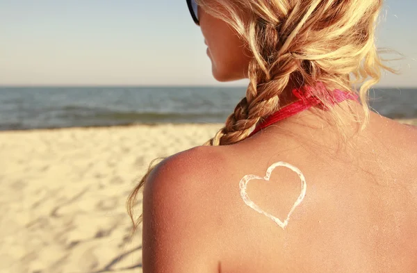 Corazón de la crema en la espalda femenina —  Fotos de Stock