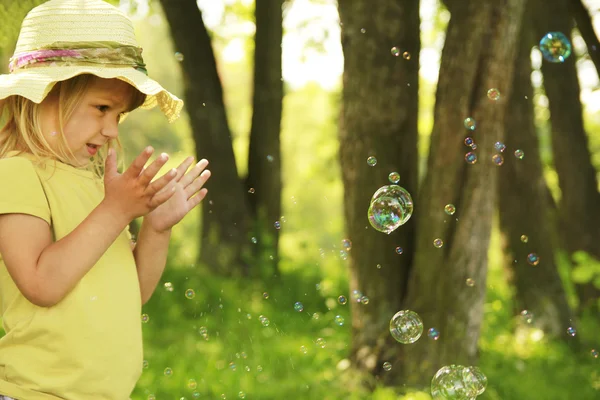 Liten flicka på naturen med såpbubblor — Stockfoto