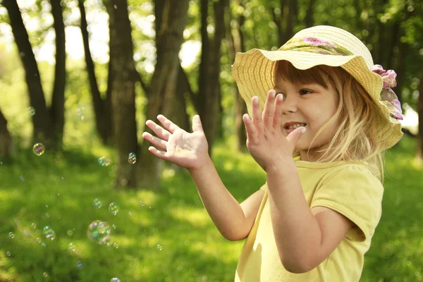 Little girl on nature with soap bubbles — Stock Photo, Image