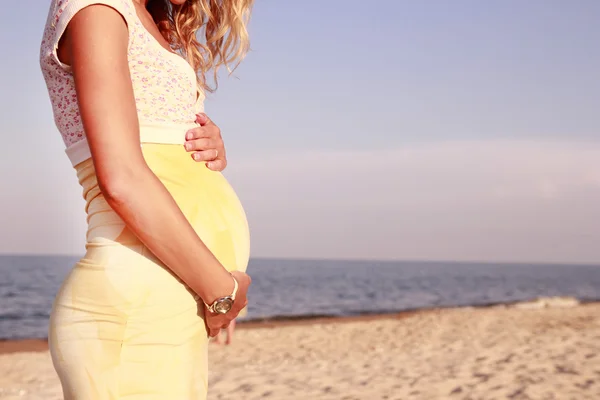 Zwangere vrouw op het strand — Stockfoto