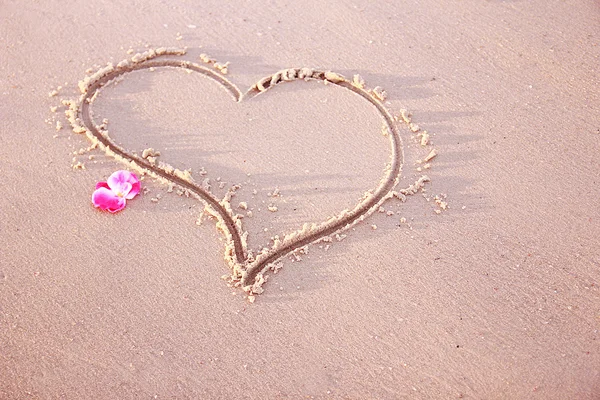 Сердце в песке на берегу моря — стоковое фото