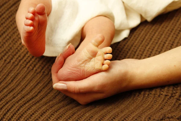 母の手で小さな新生児を足します。 — ストック写真