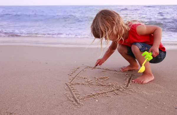 Bambina disegna una casa in riva al mare — Foto Stock