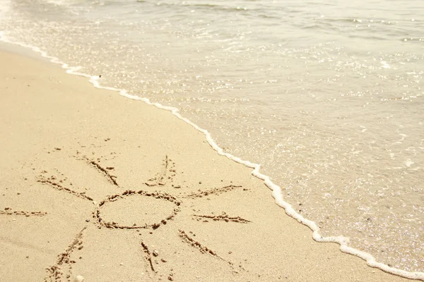 Sol dibujado en la arena en la orilla del mar — Foto de Stock