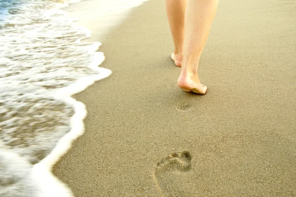 Een man verlaat voetafdrukken in het zand — Stockfoto