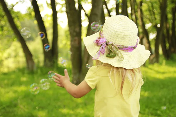 Liten flicka på naturen med såpbubblor — Stockfoto