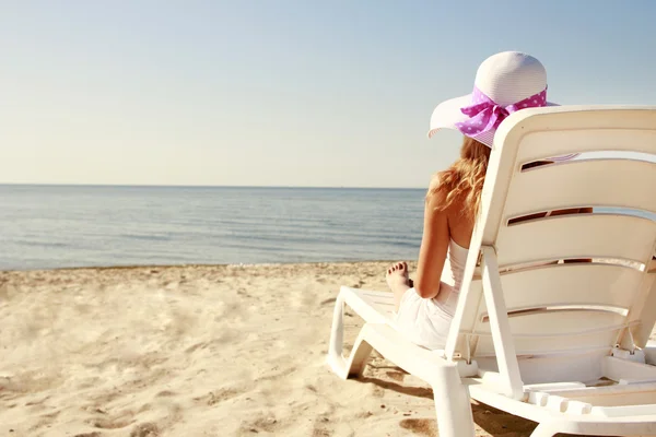 Jong meisje in de hoed op het strand — Stockfoto