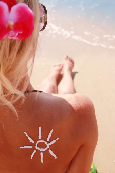 Nap krém, a női hátsó-a tengerparton — Stock Fotó