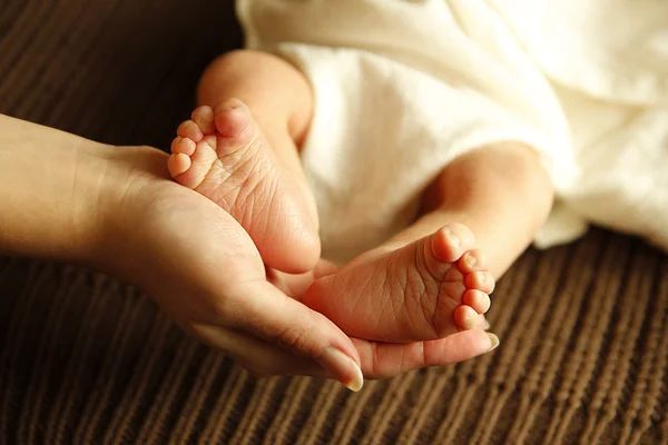 Legs newborn little baby in mother's hands — Stock Photo, Image