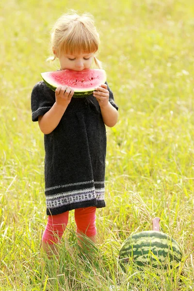 Ittle menina comendo melancia na natureza — Fotografia de Stock