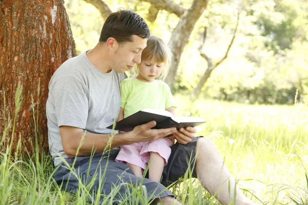 Father with little daughter reads the Bible — Stock Photo, Image