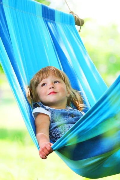 Vacker liten flicka liggande i en hängmatta — Stockfoto