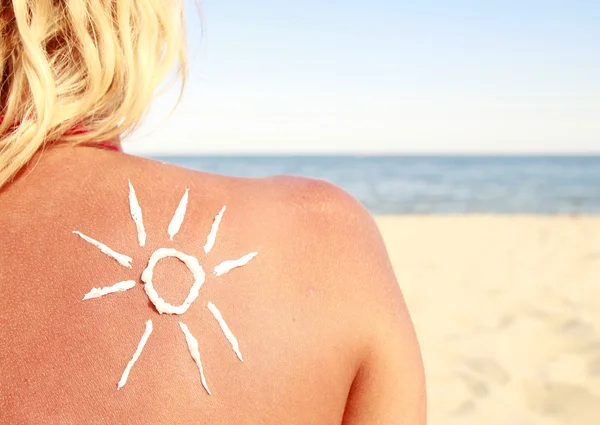 Sonnencreme auf dem Rücken der Frau am Strand — Stockfoto