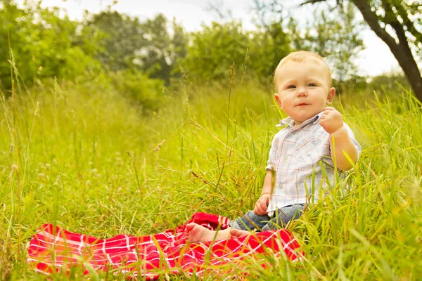 Bambino seduto nella natura — Foto Stock