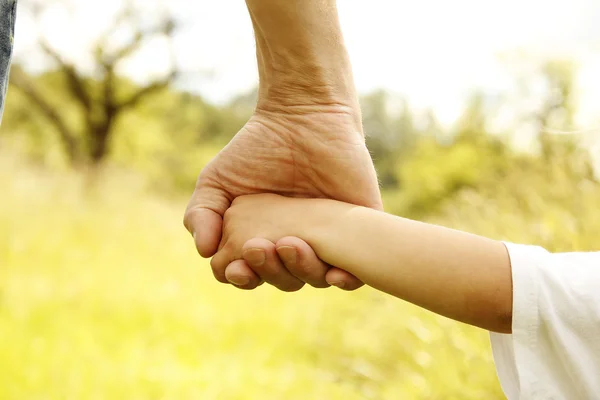 Eltern halten die Hand eines kleinen Kindes — Stockfoto