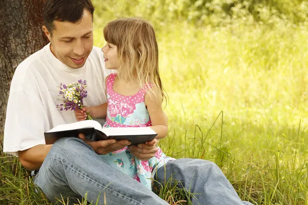 Padre con hija pequeña lee la Biblia — Foto de Stock