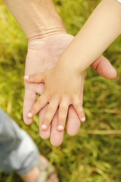 Ouder houdt de hand van een klein kind — Stockfoto