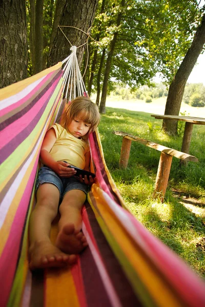 Girl with smartphone in hammock — Stock Photo, Image