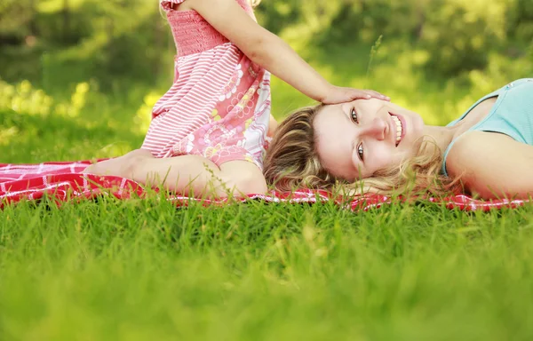 Mother and daughter lie on the grass — Stock Photo, Image