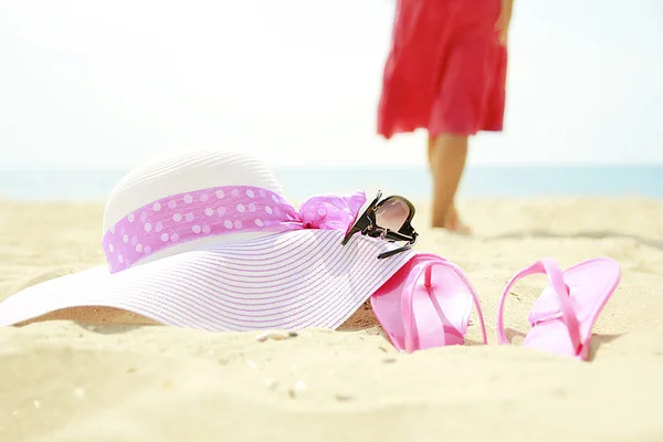 Girl with slippers and hat on the beach — Stock Photo, Image