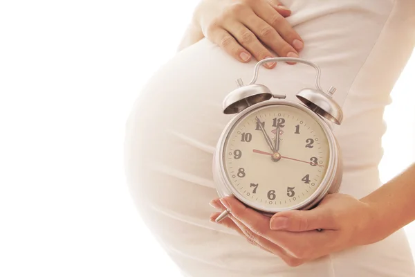 Pregnant woman with alarm clock — Stock Photo, Image