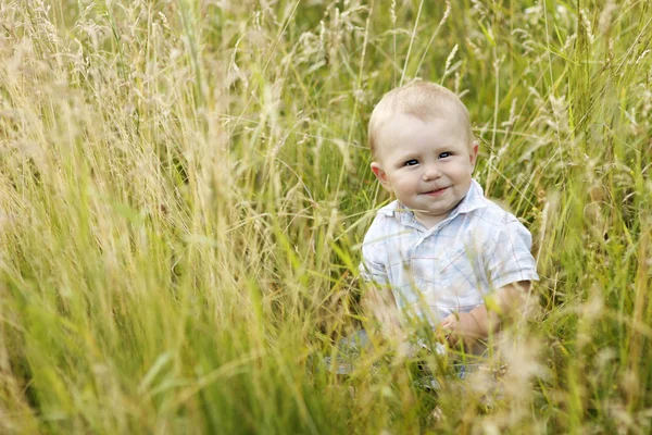 Menino brincando na grama alta — Fotografia de Stock