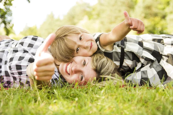 Mor och dotter ligga i gräset — Stockfoto