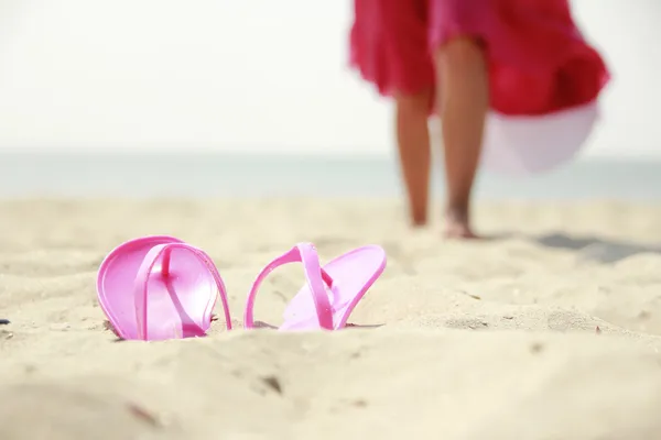 Girl with slippers on the beach — Stock Photo, Image