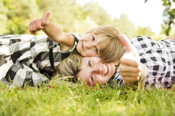 Mor och dotter ligga i gräset — Stockfoto