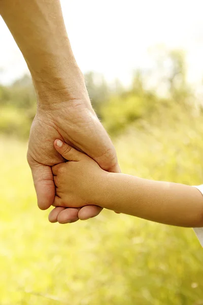 Il genitore tiene la mano di un bambino — Foto Stock