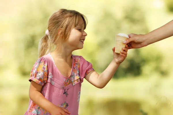 Девушка берет мороженое из рук — стоковое фото
