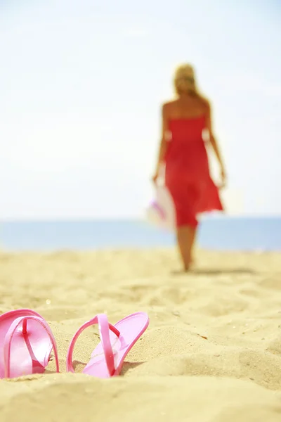 Girl with slippers on the beach — Stock Photo, Image