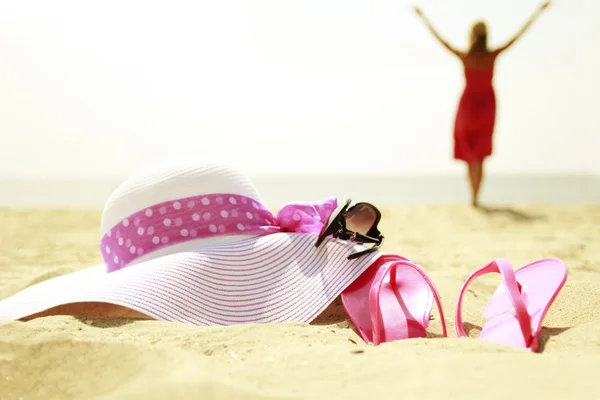 Girl with slippers and hat on the beach — Stock Photo, Image