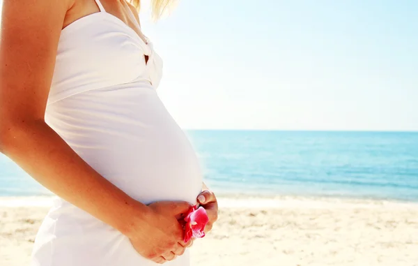 Zwangere vrouw op het strand — Stockfoto