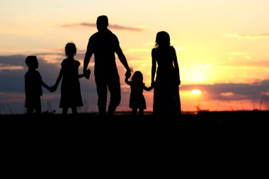 Denizde mutlu bir aile silueti. Doğada yansıması var.