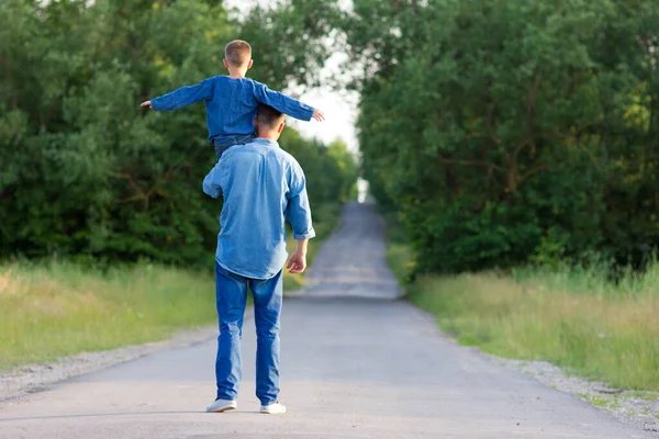 幸せな父と息子は手をつないで道路を歩き — ストック写真