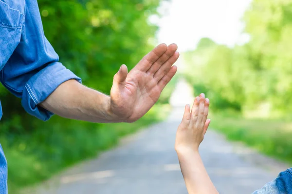 公園内の道路上の自然上の幸せな親と子供の手 — ストック写真