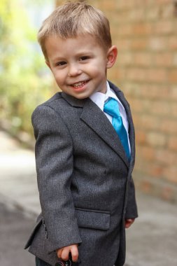 Parkta ceketli mutlu çocuk.