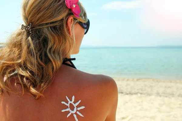 太陽の海岸で女性の背中にクリームから — ストック写真