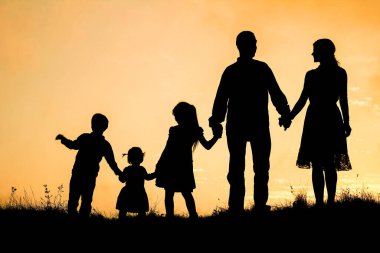 Deniz kenarında mutlu bir aile, doğanın siluetinde.
