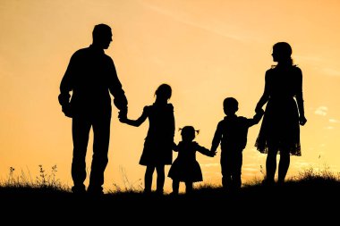 Deniz kenarında mutlu bir aile, doğanın siluetinde.