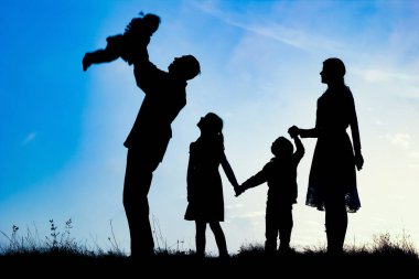 Deniz kenarında mutlu bir aile, doğanın siluetinde.