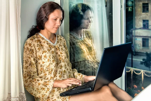 The young woman at the window with a laptop — Stock Photo, Image