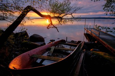 Tekne karada ve iskelede gün batımında arka planda