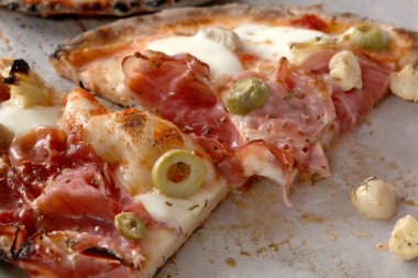 Jambonlu, zeytinli ve peynirli pizza dilimleri..