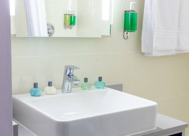 Tuvalet lavabosu küçük şişelerle dolu bir otelde.